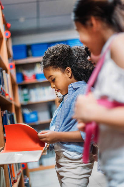istock schoolgirls looking for books in library 863114204