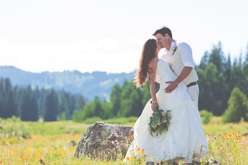 Summer wedding series stock photo shoot with couple in their thirties redhead bride and black hair groom outdoors in Colorado Grand Mesa National Forest area in July