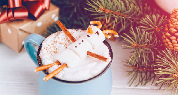 istock a mug with hot chocolate on a wooden table with a marshmallow man who is resting in a mug 863114404
