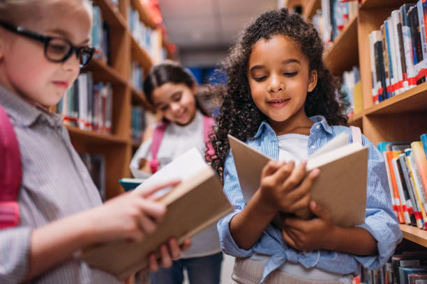 istock schoolgirls looking for books in library 863114486