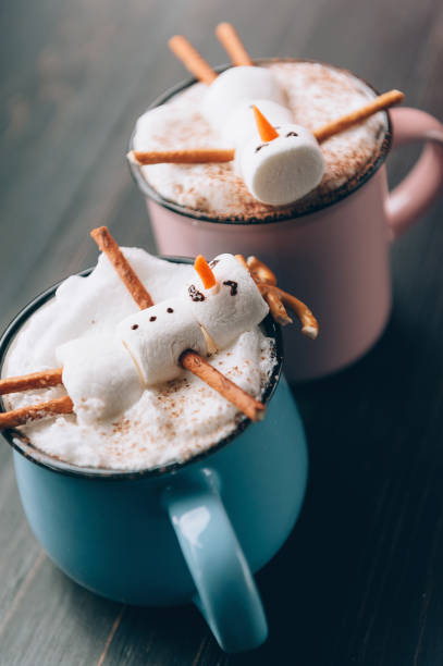 istock a mug with hot chocolate on a wooden table with a marshmallow man who is resting in a mug 863114710