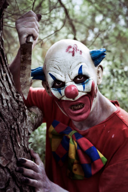 istock scary evil clown wielding a knife in the woods 863128512