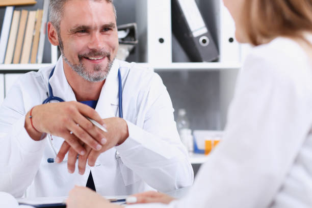istock Smiling handsome mature doctor communicate with patient 863133388
