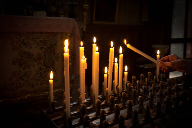 istock Woman lighting prayer candle 863138124