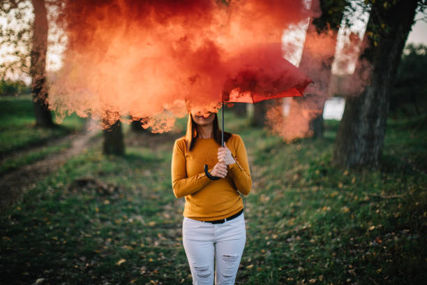 istock Woman with smoking umbrella at park 863141540