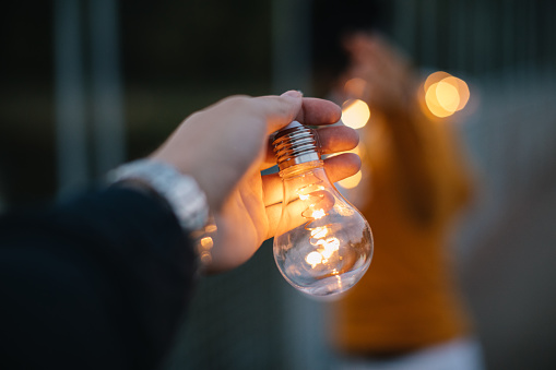 Couple standing on the bridge and holding light bulbs