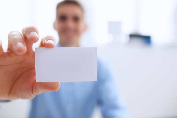 istock Smiling Business man in suit hold in hand blank calling card 863152854