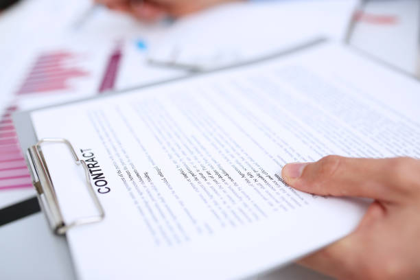 istock Male arm in suit offer contract form on clipboard pad 863152874
