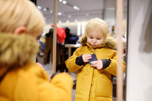 istock Cute little boy trying new coat during shopping 863158562