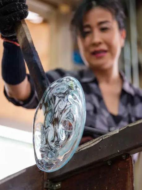 A Japanese woman working in a glass blowing factory in Okinawa, Japan.