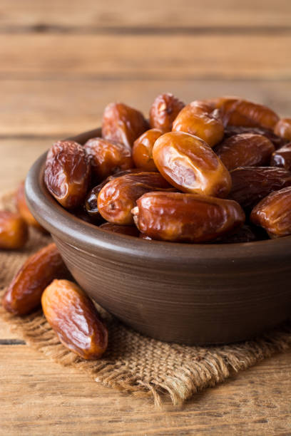 istock Dried dates fruit in ceramic bowl on wooden table. 863168338