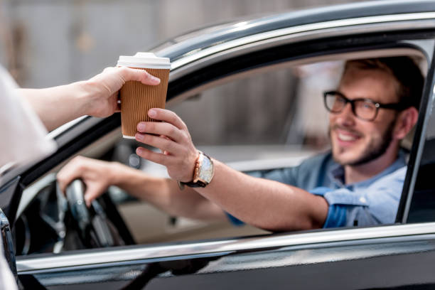 uomo con caffè in auto - food motivation driving drive foto e immagini stock