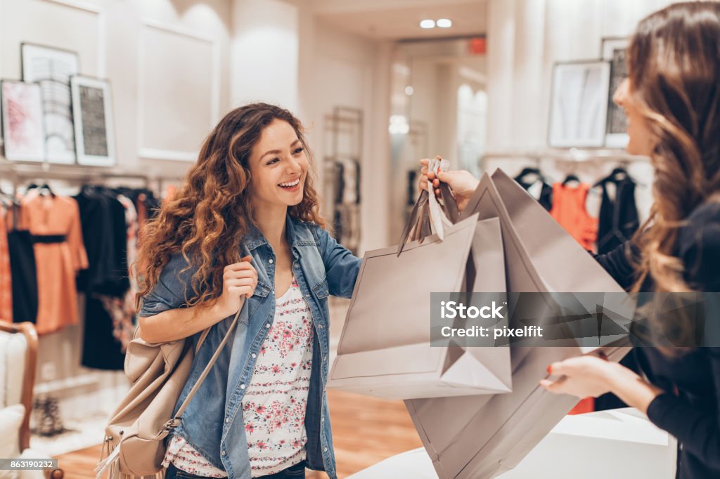 Happy girl shopping in the fashion store Young woman taking her shopping bags in a fashion store Shopping Stock Photo