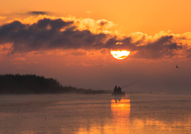 istock fishermen in a boat at dawn, bright colors 863195320