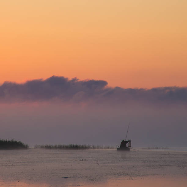 istock fishermen in a boat at dawn, bright colors 863195494