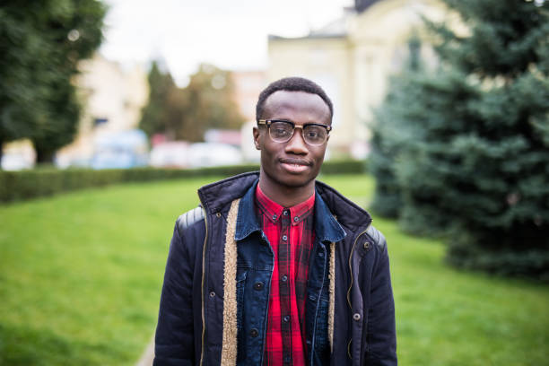 istock Modern College Student carrying shoulder leather bag, an African American guy standing by wall on street 863203918