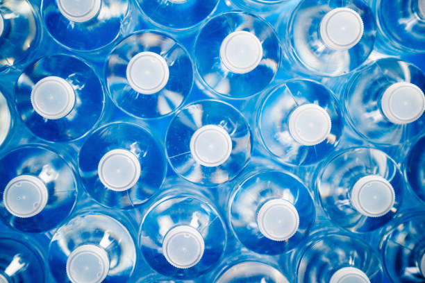 Plastic Bottles For Recycling And Energy Saving High angle view of plastic water bottles in a row. Concept of industrial production, recycling, disposal of waste, and environmental conservation. bottling plant stock pictures, royalty-free photos & images