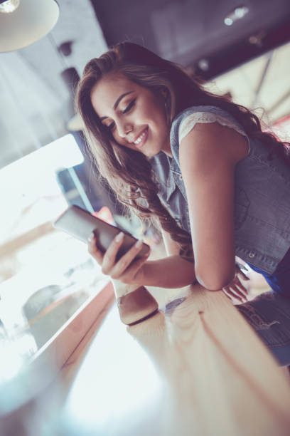 istock Young Female Using Smartphone at her Favorite Coffee Shop 863237390