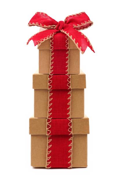 istock Stacked brown gift boxes with red bow and ribbon isolated on white 863240372
