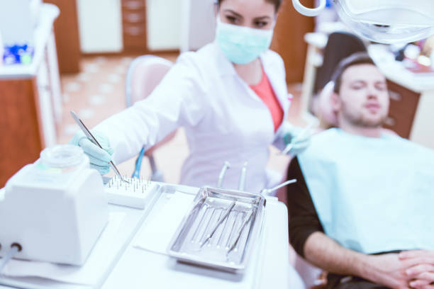 istock Female Dentist With Instruments Examining Young Male Patient 863249206