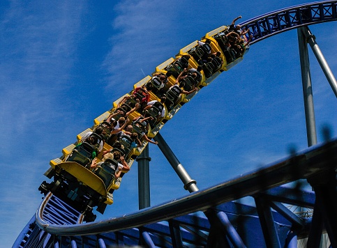 A roller Coaster sweeps up a curving track.