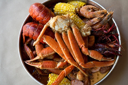 A Cajun seafood boil, with shrimp, lobster, crawfish, prawns, andouille sausage, crab legs, and corn.