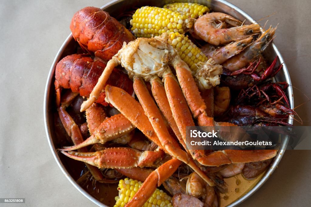 Low country boil A Cajun seafood boil, with shrimp, lobster, crawfish, prawns, andouille sausage, crab legs, and corn. Crab - Seafood Stock Photo