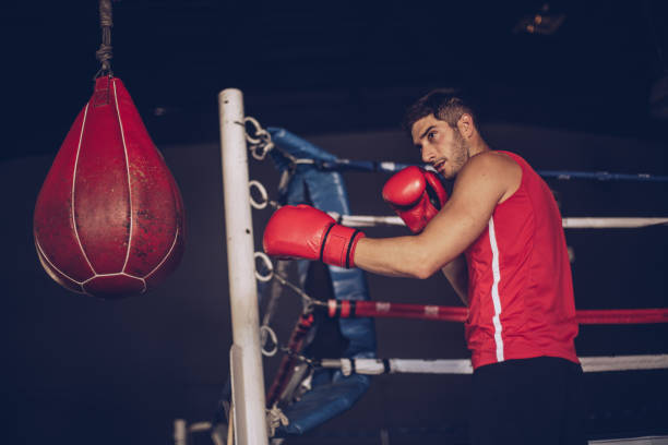 istock Boxer punching the bag in the gym 863264494