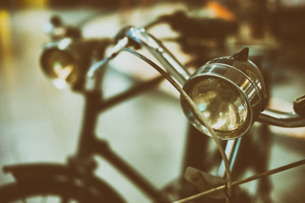 Old bike tided to metal fence, interior of a building hall.
