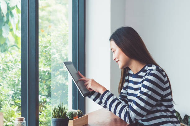 istock Asian woman using on tablet computer near window at cafe restaurant,Digital age lifestyle,Technolgy using concept. 863269922