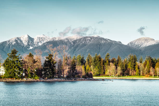 Cloudscape over the Stanley Park forest and Siwash Rock as seen from near the 5.5 km marker of the Stanley Park Seawall pedestrian footpath.