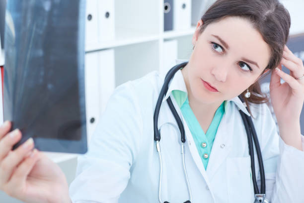 istock Young female doctor looking at x-ray 863282456