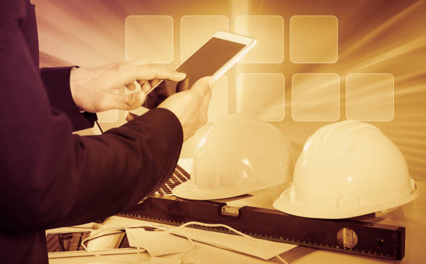 istock Businessman using phone on hardhats background 863282504