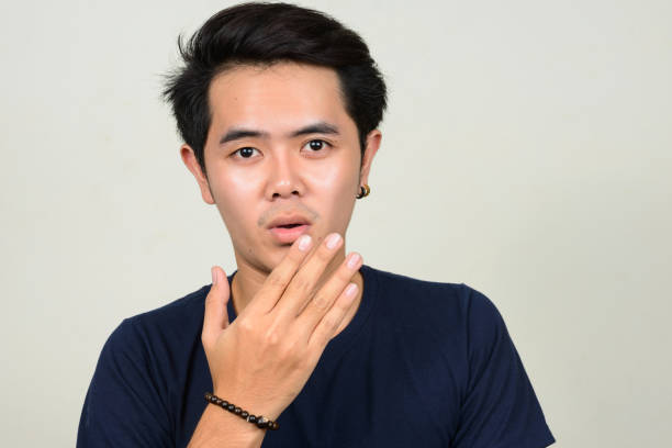 istock Young Asian man wearing blue shirt against white background 863303894