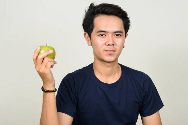 istock Young Asian man wearing blue shirt against white background 863306772