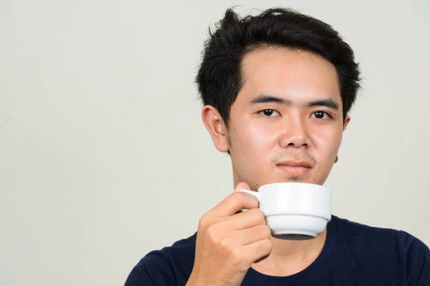 istock Young Asian man wearing blue shirt against white background 863307398
