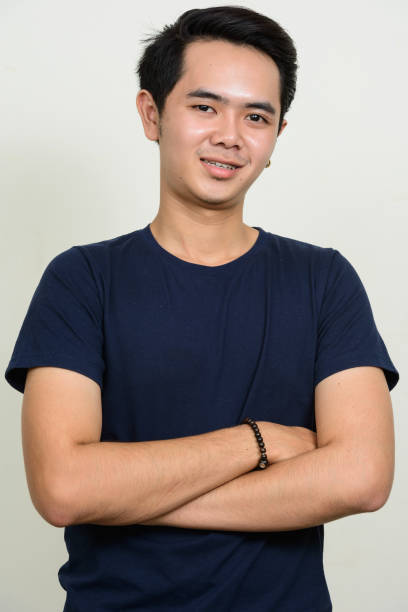 istock Young Asian man wearing blue shirt against white background 863312190