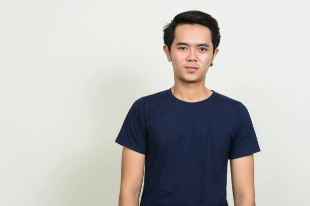 istock Young Asian man wearing blue shirt against white background 863312200