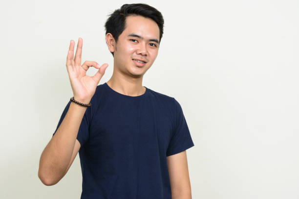 istock Young Asian man wearing blue shirt against white background 863312404