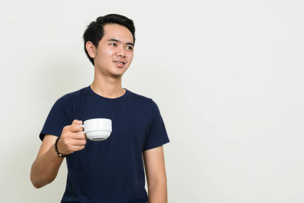 istock Young Asian man wearing blue shirt against white background 863312406