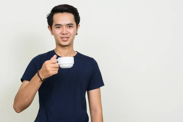 istock Young Asian man wearing blue shirt against white background 863312442