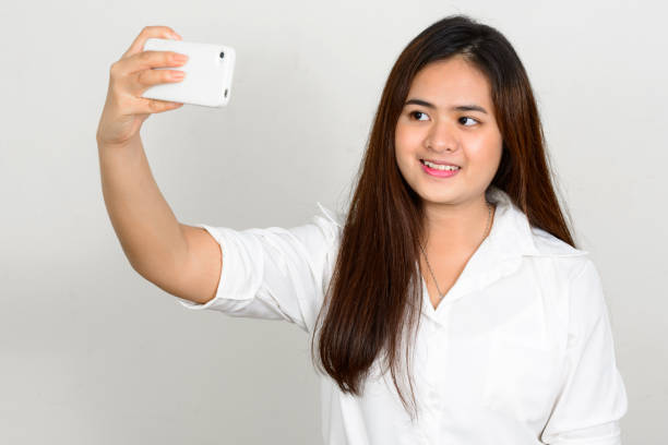 istock Young beautiful Asian woman using mobile phone against white background 863323810