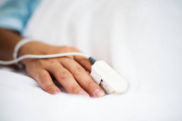 Closeup of hand with finger pulse oximeter Closeup of hand with finger pulse oximeter pulse oxymeter stock pictures, royalty-free photos & images