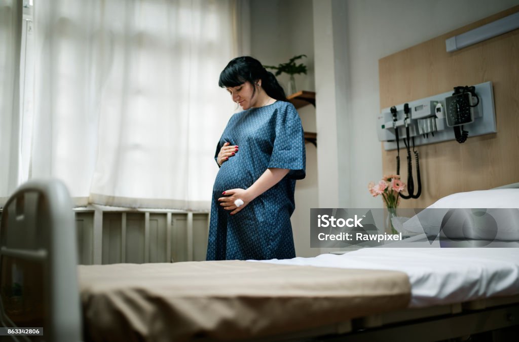 Une femme enceinte de trimestre - Photo de Être enceinte libre de droits