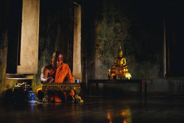 istock Asian Old monk thinking for writing something at Ayutthaya sanctuary temple in Thailand, about religion. 863365694