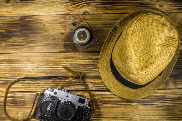 istock Compass, hat and retro photo camera on wooden background 863371054