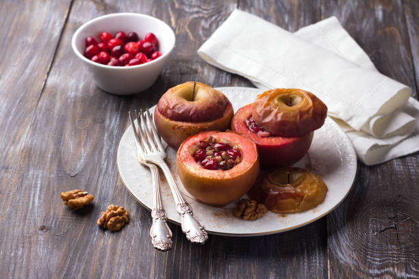 pieczone jabłka nadziewane żurawiną, orzechami włoskimi i miodem z cynamonem na drewnianym stole - baked apple apple dessert stuffed zdjęcia i obrazy z banku zdjęć