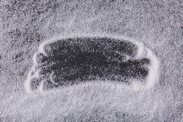 Texture of white sugar crystals on a black background. With place for text.