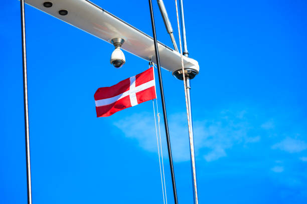 istock Denmark flag on ship mast, blue sky in background 863421132