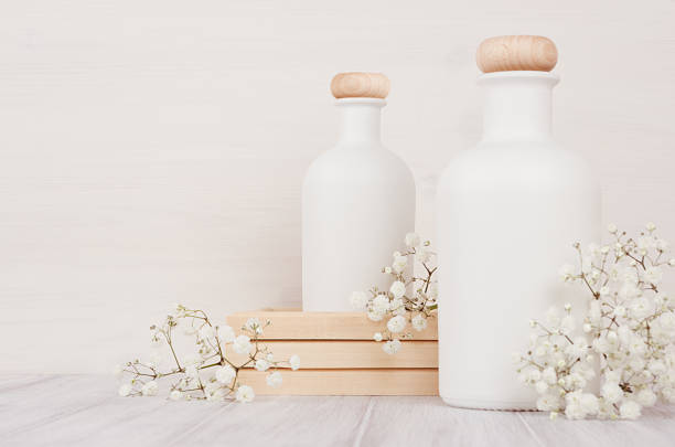 istock Blank white cosmetics bottles with small flowers on white wood board, copy space, mock up. 863431514